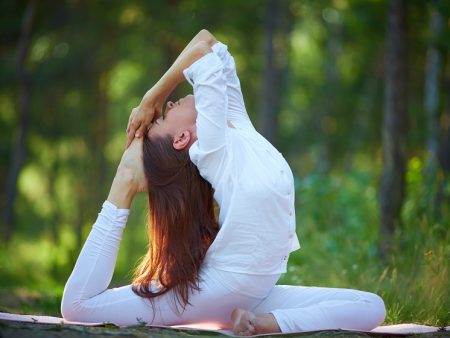 Photo of active and fit girl doing stretching exercise in natural environment